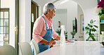Old woman, cleaning and wipe table for hygiene, chores and housekeeping in home. Housework, senior person and  surface disinfection with cloth for bacteria, virus and germ prevention in retirement