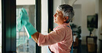 Cleaning, window and mature woman with cloth for hygiene, housekeeping and maid service. Washing, glass and senior person with shine, detergents and liquid for bacteria, disinfection and dust in home