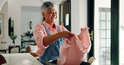 Buy stock photo Happy old woman, cleaning and folding laundry in home for housekeeping or hygiene maintenance. Housework, person and fabric in basket for chores, morning routine and organizing clothes in retirement