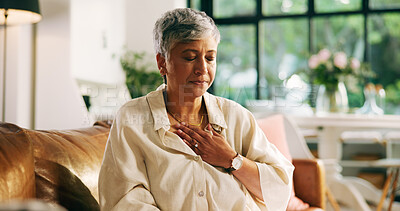 Buy stock photo Living room, chest pain and mature woman with heartburn, health risk or angina with medical emergency. Retirement, heart attack and person with cardiovascular disease, cardiac arrest and hypertension