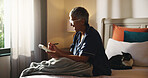 Home, crossword and senior woman with smile, relax and problem solving with intelligence. Apartment, pensioner and mature person in bedroom, book and games with solution, answer and creative activity