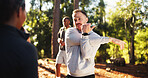 Man, fitness and stretching with arms in forest for workout preparation or physical activity. Male person, runner or getting ready in group warm up for outdoor exercise, hiking or trekking in nature