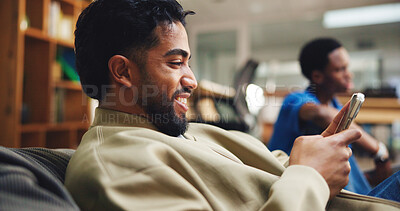 Buy stock photo Phone, man and student relaxing in library with networking, connectivity or contact on mobile app. Happy, bean bag and male person with cellphone for texting with communication online on campus.