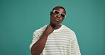 Black man, fashion and sunglasses with trendy, style and confidence on green studio background. Gen Z, male person portait or serious African model with accessory, shades or eyewear on mockup space