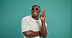 Peace sign, sunglasses and face of black man in studio with trendy style, clothes and outfit. Emoji, fashion and portrait of person with accessories and confidence, pride and smile on blue background