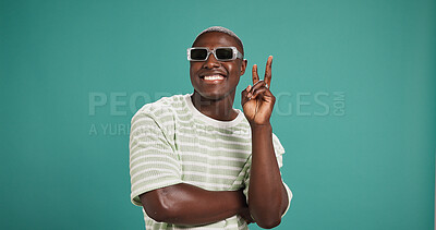 Buy stock photo Peace sign, sunglasses and face of black man in studio with trendy style, clothes and outfit. Emoji, fashion and portrait of person with accessories and confidence, pride and smile on blue background