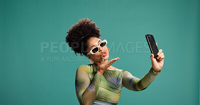Buy stock photo Selfie, blowing kiss and woman in studio, picture and social media on green background. Person, space and model with emoji, photography and content creation with confidence, sunglasses and influencer