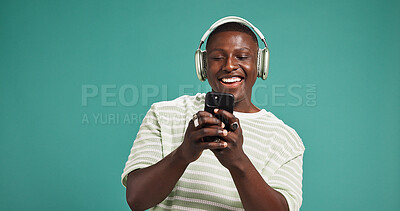 Buy stock photo Headphones, smile and black man in studio, smartphone and listening to music on green background. African person, space and mobile user with headset, sound and cellphone with podcast, app and radio