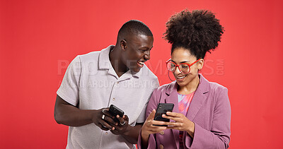 Buy stock photo Happy couple, funny or meme with phone in studio for social media or fashion on red background. Online post, laughing or people with smile or mobile app for chat notification, joke and trendy clothes