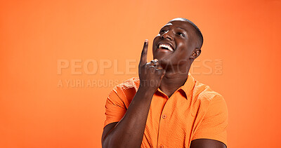Buy stock photo Idea, pointing and space with black man in studio for presentation, announcement and show. Smile, advertising and opinion with person on orange background for launch news, promotion and direction