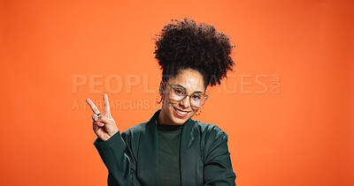 Buy stock photo Smile, portrait and woman with peace sign in studio for social media influencer. Happy African person, glasses and v hand gesture, emoji and symbol for victory on orange background with space