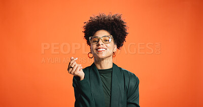 Buy stock photo Heart, happy and portrait of woman in studio for love, support and gratitude on orange background. Fashion, smile and person with emoji, gesture and fingers for kindness, thank you and affection