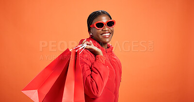 Buy stock photo Space, shopping bag or happy black woman in studio for fashion choice and financial freedom. Mockup, customer or cool African person on orange background for clothes sale, discount deal or bargain