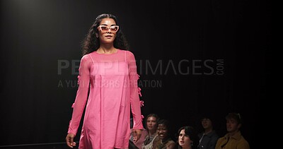 Buy stock photo Woman, model and walking on catwalk with fashion, confidence or showcase with audience. Style, sunglasses and person at black background space with designer clothing, brand ambassador or runway event