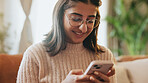 Woman, phone and happy with texting on sofa, relax and glasses in lounge post on web at house. Person, smartphone and smile in home, mobile app and chat notification on social media in living room