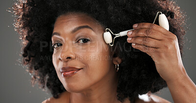 Buy stock photo Woman, quartz roller or cosmetics in studio for facial routine, stone or antiaging by gray background. Black person, beauty or portrait for massage tools, circulation or skincare for results in Kenya