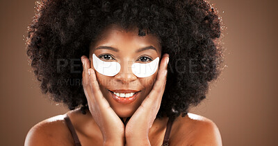 Buy stock photo Eye mask, beauty and portrait of black woman in studio for dark circles, hydration and wellness. Dermatology, happy and African person with pads for collagen, anti aging or health on brown background