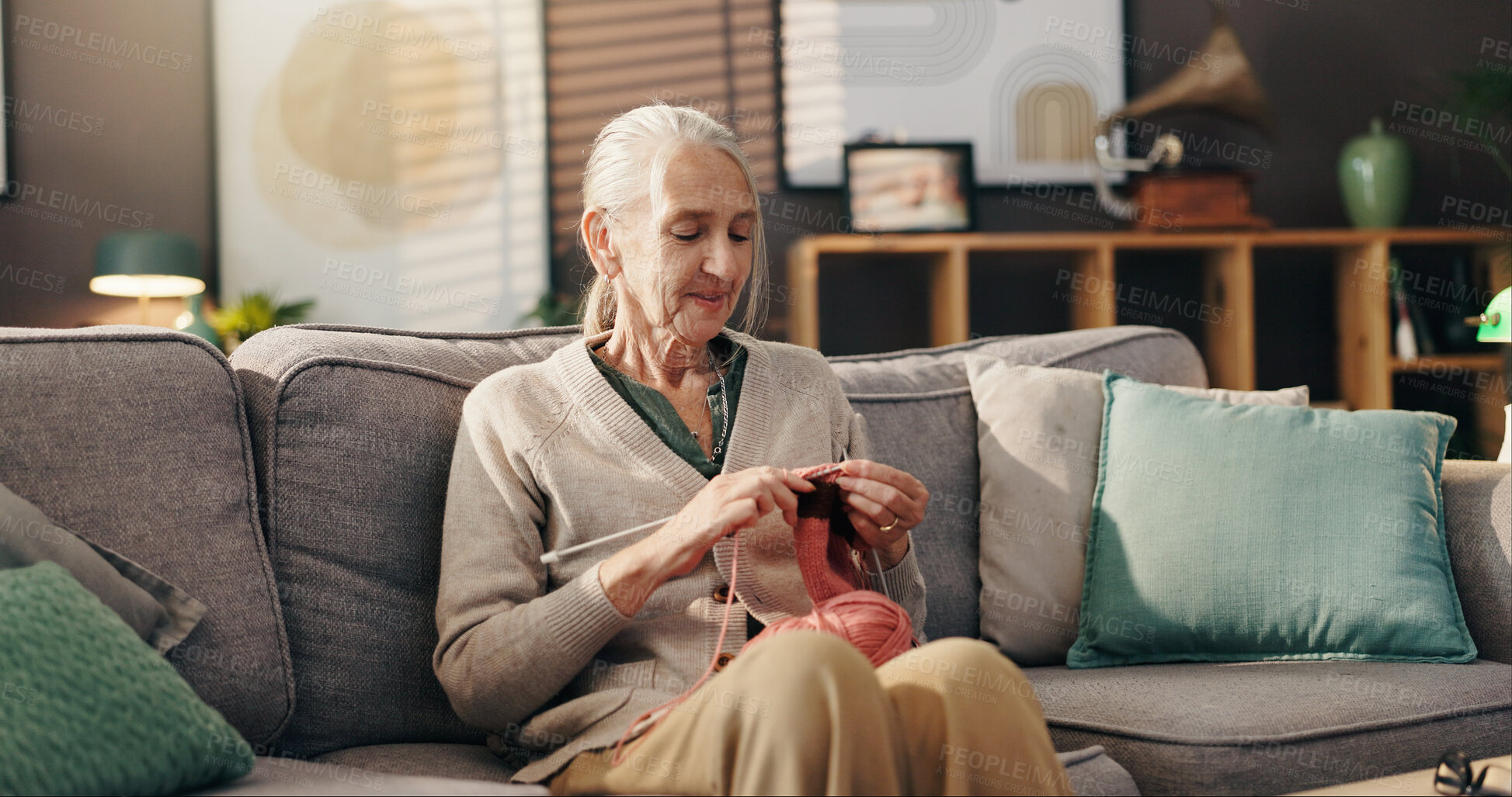 Buy stock photo Senior woman, relax and knit on sofa for retirement hobby, cognitive stimulation and DIY scarf. Wool, yarn or old person with craft in home for handmade jersey, peaceful activity and organic creation