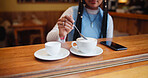 Hands, cafe and woman stirring coffee on table for beverage, espresso and drink preparation. Cup, latte and customer with spoon for mixing morning cappuccino with fresh cream in restaurant to relax