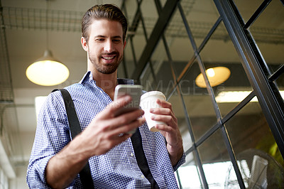 Buy stock photo Below, business and man in office, smartphone and smile with social media, texting and coffee. Person, employee and web designer in workplace, herbal tea and cellphone with digital app and contact