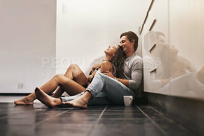 Buy stock photo Love, laugh and couple on kitchen floor with coffee, morning bonding together and relax in home with smile. Romance, happy man and woman embrace in apartment with care, connection and fun on weekend