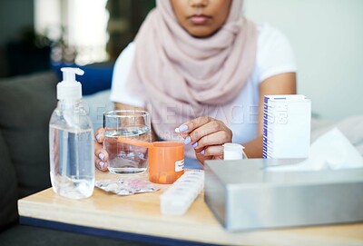 Buy stock photo Muslim, woman and sick with pills on sofa in living room with illness, flu and tired at home. Female person, lounge and fever with medication to relax, chill and calm on couch for recovery or rest
