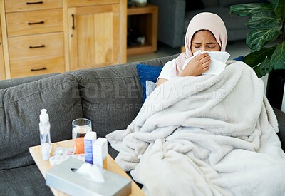 Buy stock photo Woman, muslim and blow nose or sick in home, cold and medicine for illness and treatment for health. Female person, hijab and blanket on couch for sinus, pills and virus or hayfever and recovery