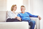 Happy mature couple relaxing together on a sofa at home