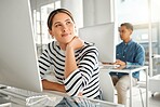 Young content mixed race businesswoman thinking and using a desktop computer in an office at work. Happy hispanic female businessperson smiling while sitting at a desk. Business professional daydreaming while working on a computer