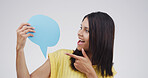 Woman, happy and point with speech bubble, studio and mock up space by white background. Excited person, smile and poster with opinion, announcement and choice with blank sign for social media