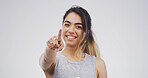 Woman, portrait and point at you in studio with smile for choice, win and mockup space on white background. Girl, happy and hand gesture for selection, decision and call to action in Colombia 