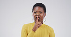 Portrait, black woman and finger on lips in studio for secret, quiet or privacy gesture for gossip. Whisper, confidential and African female person with silent hand sign for rumor by white background