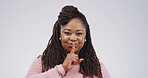 Black woman, portrait and finger with secret, studio and silence for mystery announcement. Model, gossip and hush with rumor, whisper and gesture for news, opinion and privacy on white background