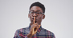 Happy, portrait and black man in studio with secret, gossip or confidential hand gesture for privacy. Quiet, smile and African male person with finger on lips for noise control by white background.