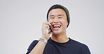 Laugh, phone call and happy Asian man in studio for communication, joke or funny story. Mobile, smile and person talking to contact for news, comedy and chat on white background space with portrait