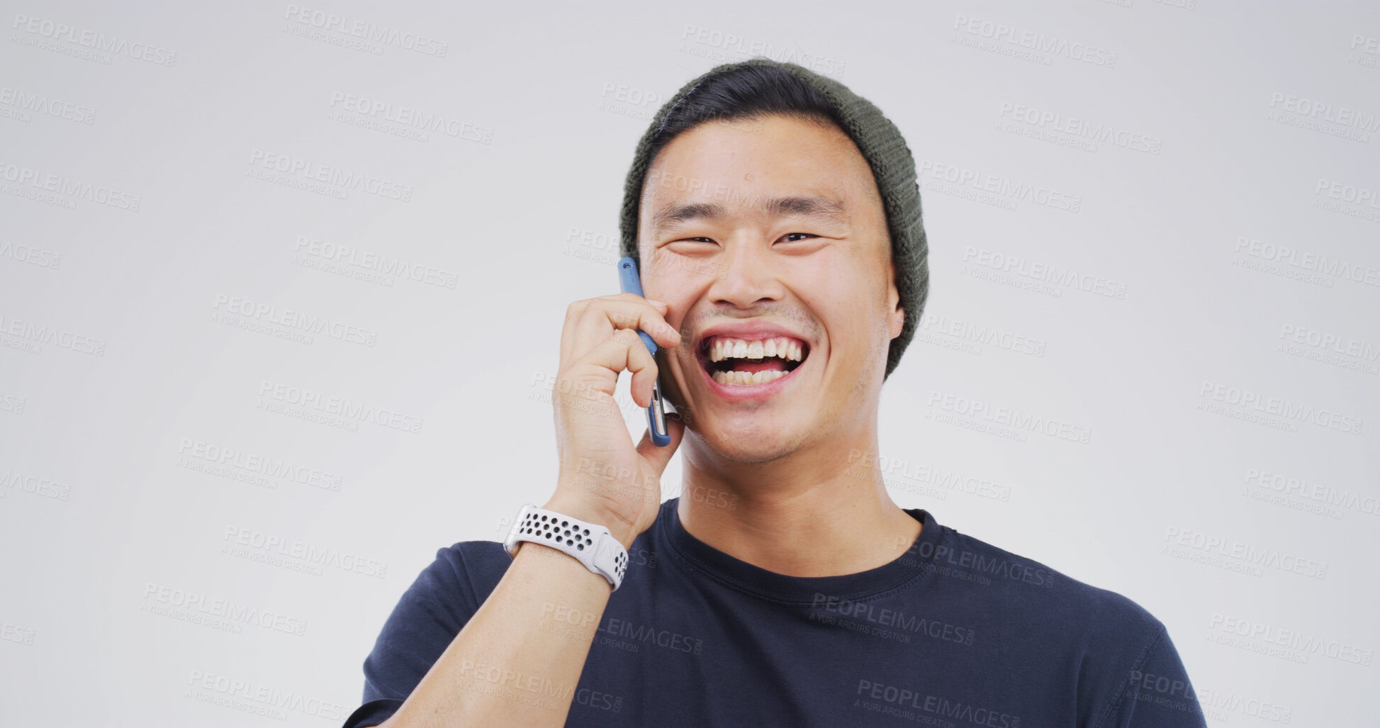 Buy stock photo Laugh, phone call and happy Asian man in studio for communication, joke or funny story. Mobile, smile and person talking to contact for news, comedy and chat on white background space with portrait