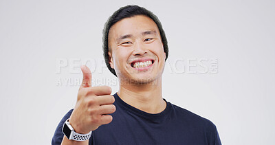 Buy stock photo Asian man, portrait and smile with thumbs up in studio, motivation or promotion with praise. Agreement, success or hand gesture for yes, thank you or feedback with sign for review on white background
