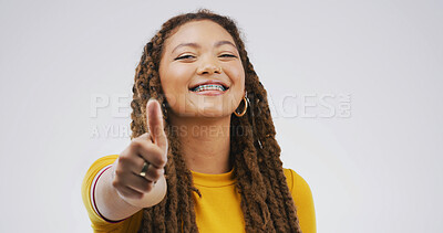 Buy stock photo Black woman, braces and thumbs up in studio for approval feedback and emoji on white background. Female person, dental health and icon for affirmation, promotion and portrait for review or great news
