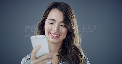 Buy stock photo News, phone and happy woman in studio for texting, social media blog and online post. Smile, technology or person with mobile for subscription, space and dating app notification on dark background