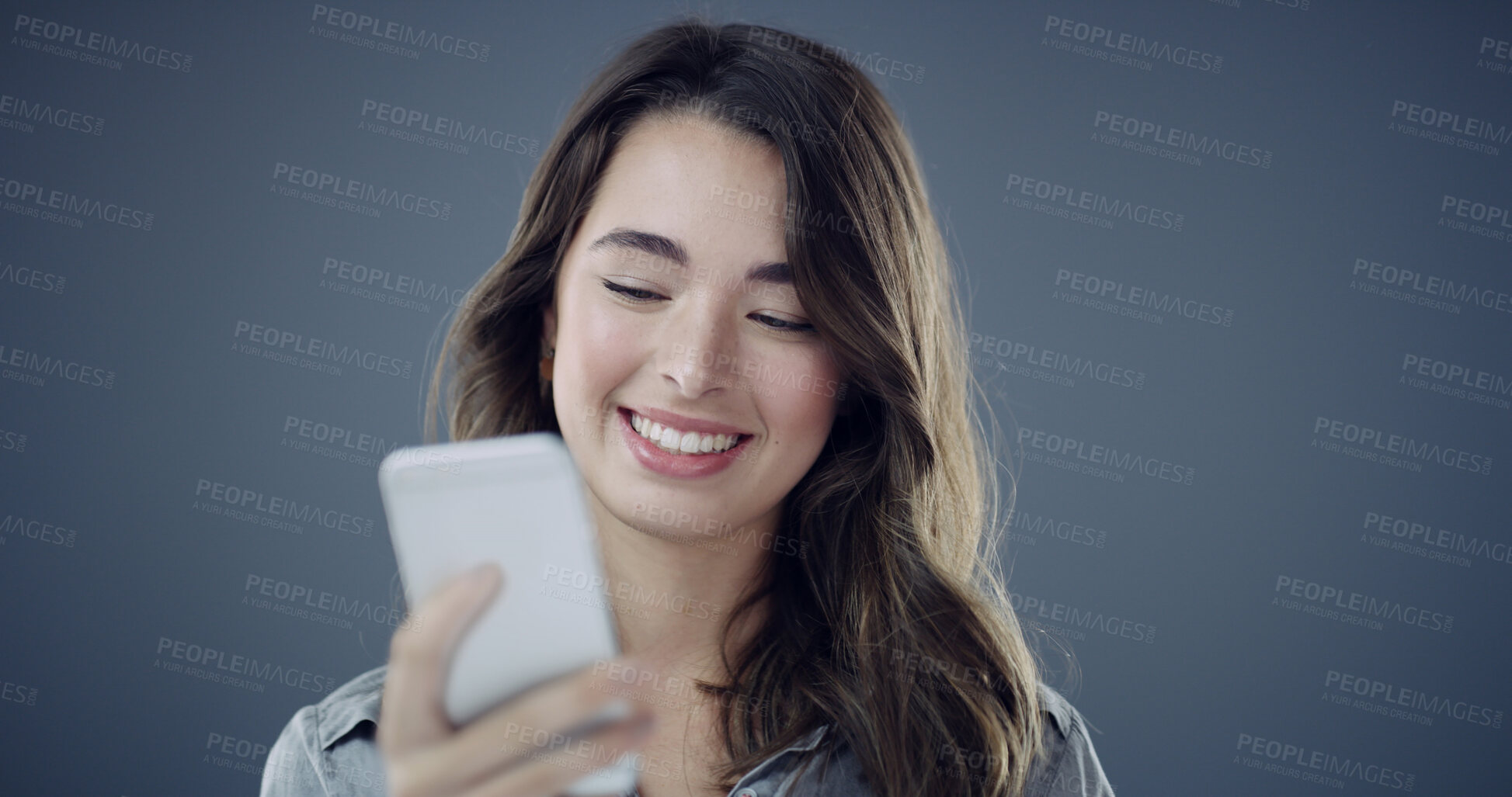 Buy stock photo News, phone and happy woman in studio for texting, social media blog and online post. Smile, technology or person with mobile for subscription, space and dating app notification on dark background