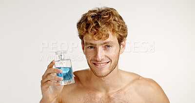 Buy stock photo Hygiene, portrait and happy man with perfume for fragrance or grooming on white studio background. Cologne, fresh scent and model with luxury cosmetics in bottle for self care, beauty or smell clean