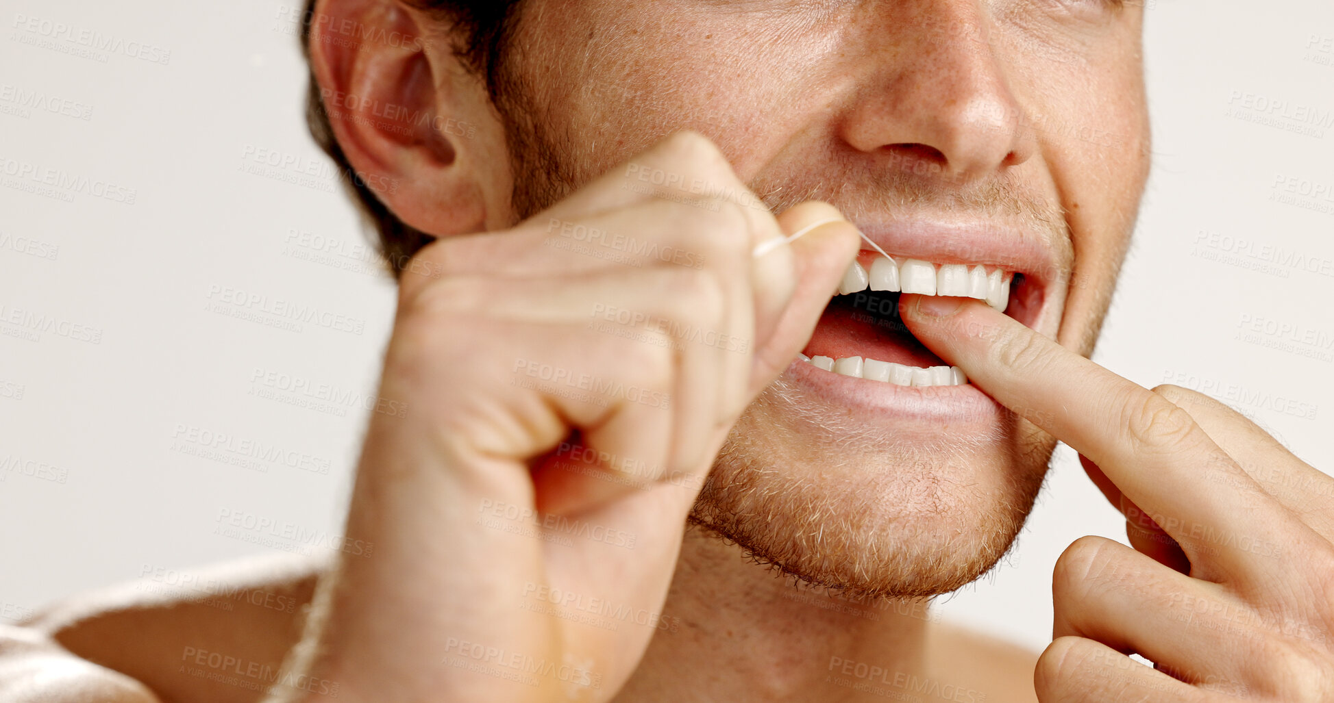 Buy stock photo Dental care, floss and man in studio with hygiene, wellness and mouth routine in morning. Oral health, fresh breath and person with string for cleaning teeth with plaque removal by white background.