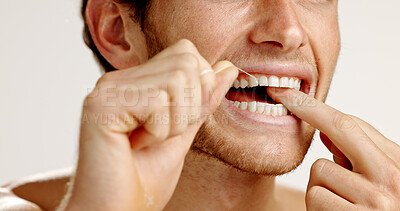 Buy stock photo Dental hygiene, floss and man in studio with wellness, health and mouth routine in morning. Oral care, fresh breath and person with string for cleaning teeth with plaque removal by white background.