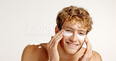 Buy stock photo Portrait, eye patches and man with smile, skincare and dermatology on white studio background. Face, mask and person with spa wellness, smooth and facial beauty with detox, treatment or cosmetics