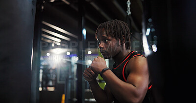Buy stock photo Black man, punching bag and boxing for fitness at gym with power, challenge or martial arts. African person, athlete or workout with fist, fight or contact sports with equipment for exercise at club