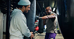 Boxing, men and personal trainer in gym, punching bag or practice for competition, sport and active. Power, fighter and training with instructor for performance, athlete and workout in fitness center