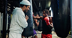 Sport, men and personal trainer in gym, punching bag or practice for competition, boxing and active. Power, fighter and training with instructor for performance, athlete and workout in fitness center