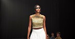 Woman, model and pose on catwalk with fashion, confidence or showcase with audience. Style, sunglasses and person at black background space with designer clothing, brand ambassador or runway event