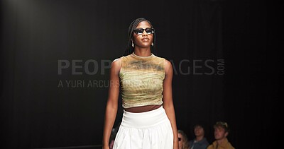Buy stock photo Woman, model and pose on catwalk with fashion, confidence or showcase with audience. Style, sunglasses and person at black background space with designer clothing, brand ambassador or runway event