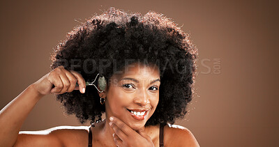 Buy stock photo Skincare, happy and woman with jade roller in studio for lymphatic drainage, radiance or routine. Mockup space, black person and cosmetics tool for anti aging and beauty portrait on brown background